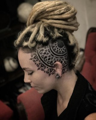  Tatouage mandala sur le coté du crane sur une ffemme avec des rastas